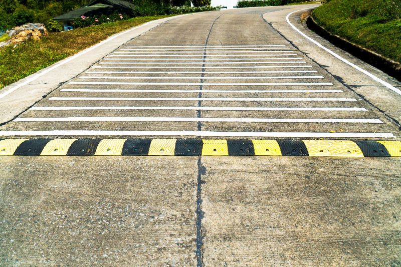 Rumble Strips How Do Rumble Strips Work? A Practical Guide for Perth Business Owners 2 Road with rumble strips, a safety feature. Yellow and black speed bump and painted white road lines. Guide to Rumble Strips: How do they work?